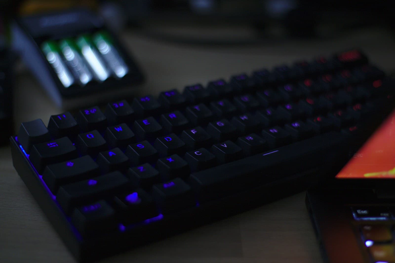 Compact black mechanical keyboard with purple and red backlighting