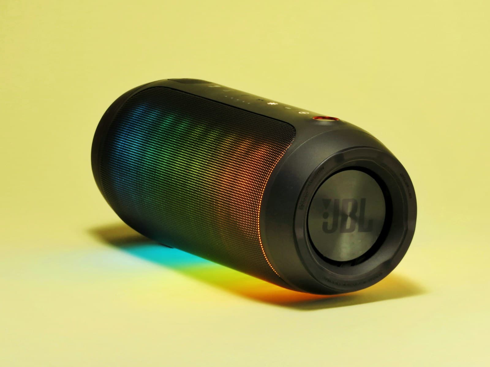 Black portable speaker with a multicolour illuminated grille